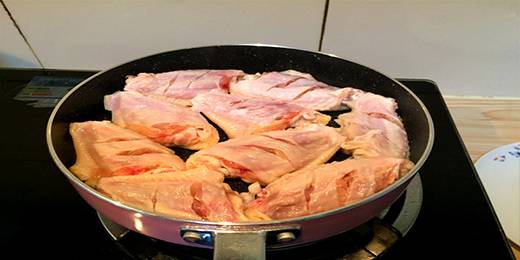 鸡翅洗干净两面花刀，干净锅烧热，放入鸡翅（建议用不粘锅）。