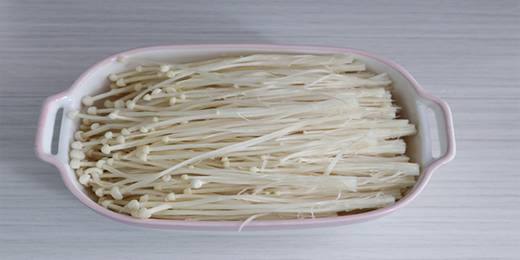 金针菇洗净，切掉根部，撕开，摆进盘里。