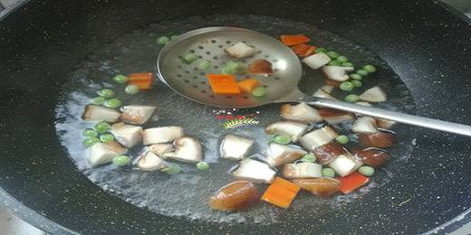 4.锅里放入适量清水烧开，放入1勺食用盐，1勺食用油，把香菇丁、胡萝卜丁、青豆放进锅里焯烫20秒捞出来控干水分。