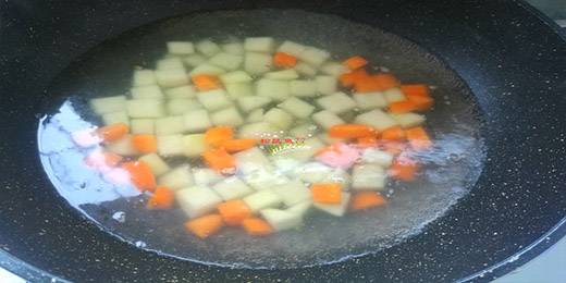 5.接着把胡萝卜丁和土豆丁放下去，焯烫2分钟至八分熟，仔细观察，土豆丁有些透明的时候就好了，捞出来控干水分。