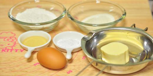 1.准备材料，柠檬擦出皮屑备用。锅里烧水，黄油隔水加热融化。少许的黄油将模具里擦一遍，容易脱模