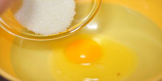 2.在盆里打入鸡蛋，放入白糖，搅拌均匀。