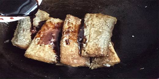 7.倒入调味汁。加适量水，盖上锅盖烧。大火烧开，改小火烧，其间适时轻轻推动鱼。收汤入味，即可出锅装盘。